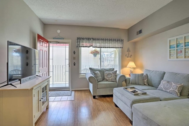 living room with light hardwood / wood-style floors and a textured ceiling