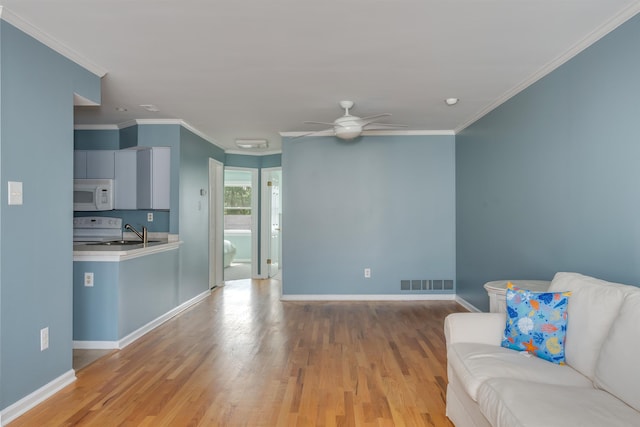1520 Yacht Ave Unit 203, Cape May, NJ 08204 - living room featuring light wood-style flooring, a ceiling fan, baseboards, and crown molding