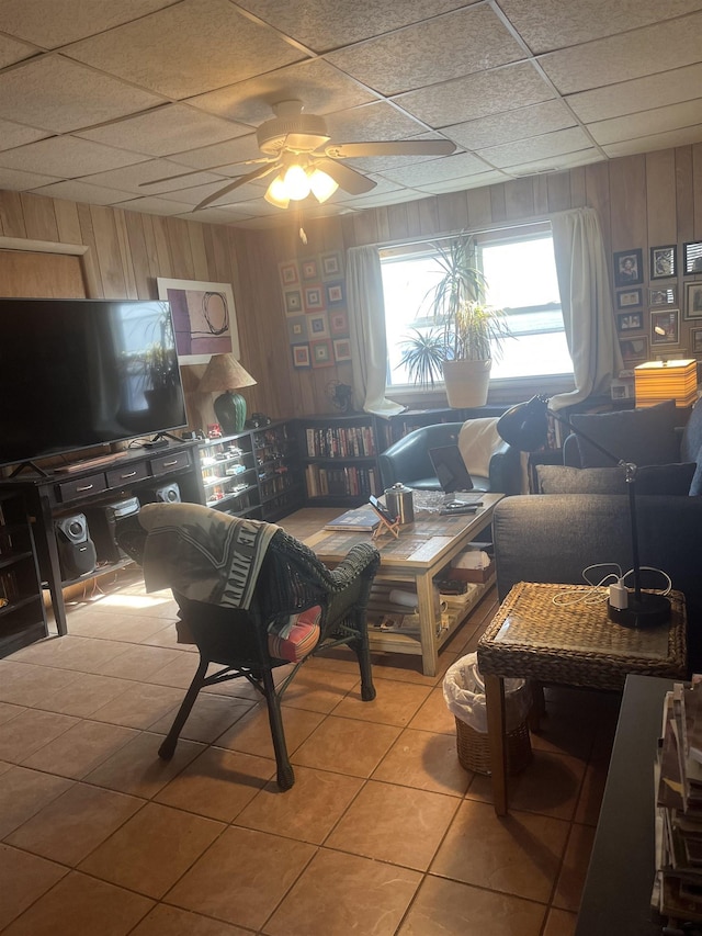 tiled living room with wood walls and ceiling fan