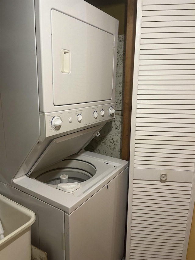 washroom featuring stacked washer / drying machine