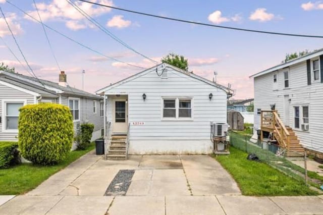 bungalow-style house featuring central AC unit and a patio area