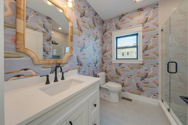 bathroom with tile patterned flooring, toilet, vanity, and a shower with shower door