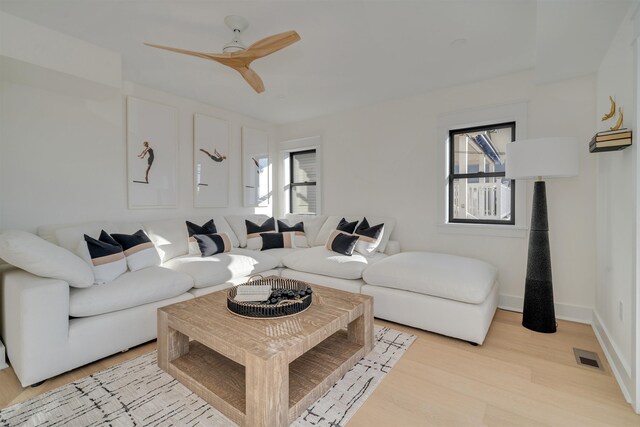 living room featuring ceiling fan, light hardwood / wood-style floors, and a wealth of natural light