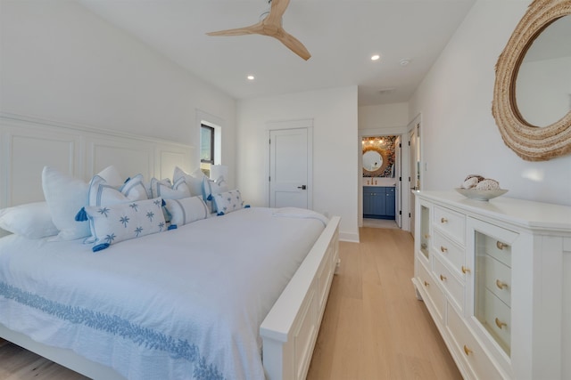 bedroom with ceiling fan, ensuite bath, and light hardwood / wood-style flooring