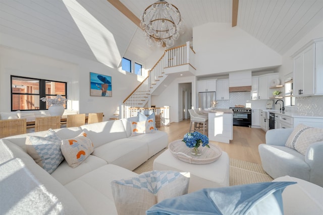 living room with sink, light hardwood / wood-style flooring, beam ceiling, high vaulted ceiling, and a chandelier