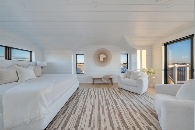 bedroom with light hardwood / wood-style flooring, vaulted ceiling, and access to outside