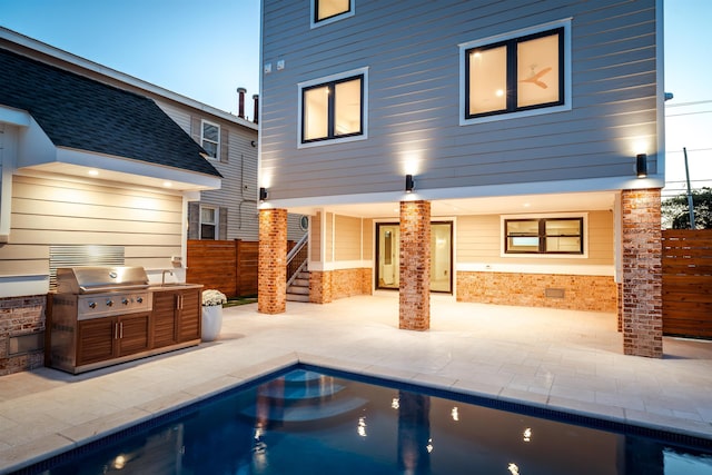 back house at dusk with area for grilling, a fenced in pool, and a patio