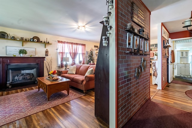 living room with brick wall and wood-type flooring