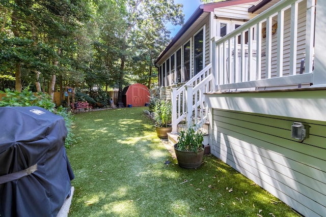 view of yard featuring a sunroom and a storage shed