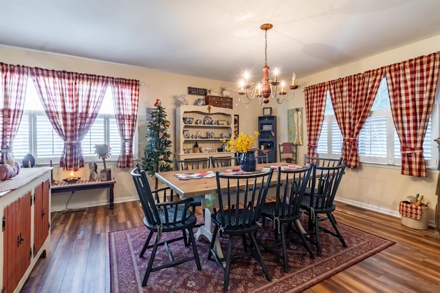 dining room with dark hardwood / wood-style flooring and an inviting chandelier