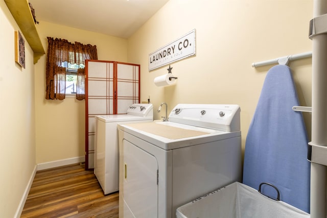 laundry room featuring hardwood / wood-style floors and washing machine and clothes dryer