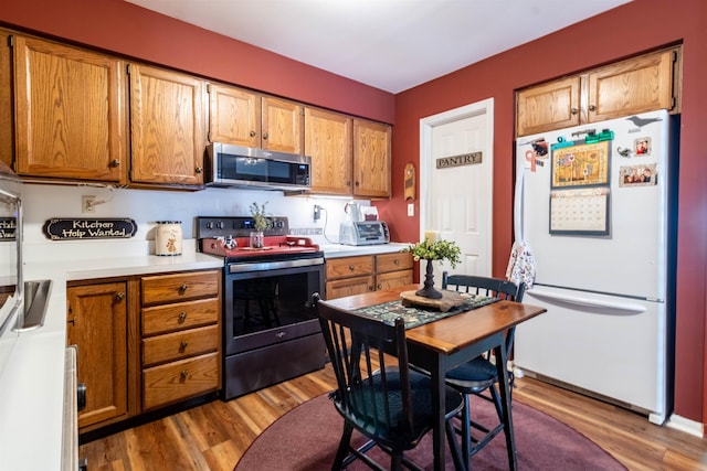 kitchen with hardwood / wood-style flooring and appliances with stainless steel finishes