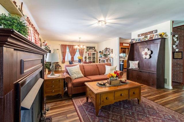 living room with brick wall, dark hardwood / wood-style floors, and a chandelier