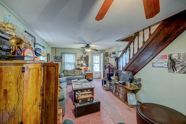 living room with ceiling fan and stairway