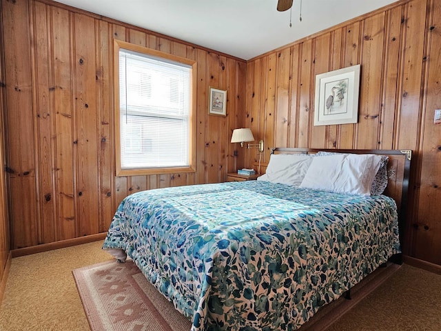 bedroom featuring baseboards, carpet floors, ceiling fan, and wooden walls