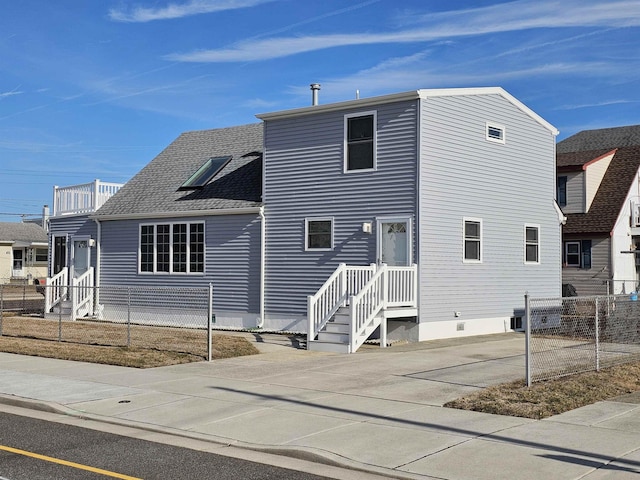 view of front of property featuring crawl space, roof with shingles, and fence