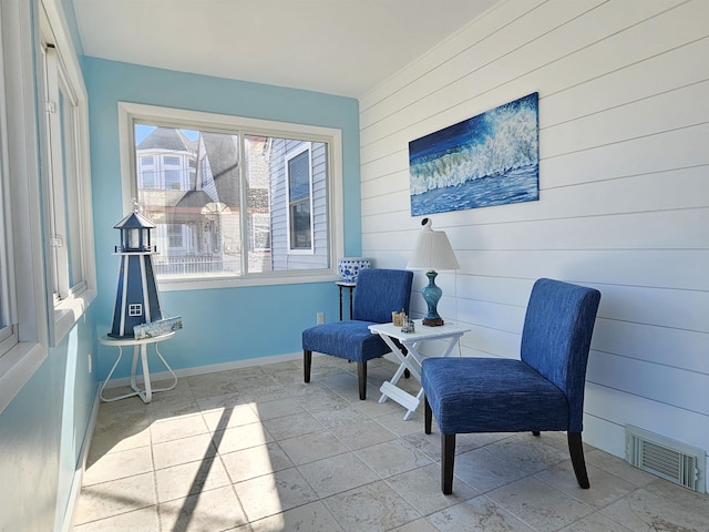 living area with baseboards and visible vents