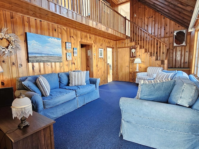 carpeted living room featuring high vaulted ceiling and wooden walls