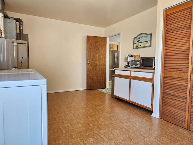 washroom with laundry area, baseboards, washer / clothes dryer, and light floors