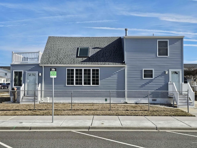 view of front of house with a fenced front yard and a shingled roof