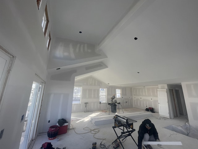 living room with beam ceiling, high vaulted ceiling, and a wealth of natural light