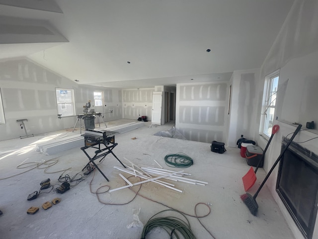 unfurnished living room featuring lofted ceiling