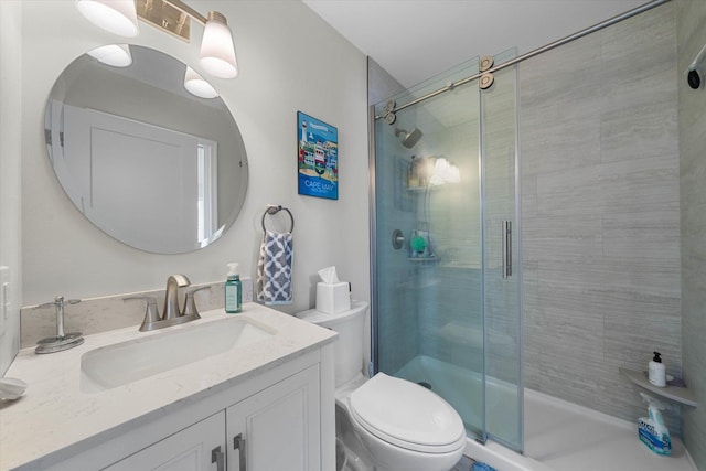 bathroom with toilet, vanity, and an enclosed shower