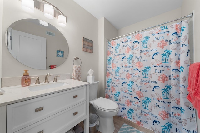 bathroom with toilet, vanity, and curtained shower