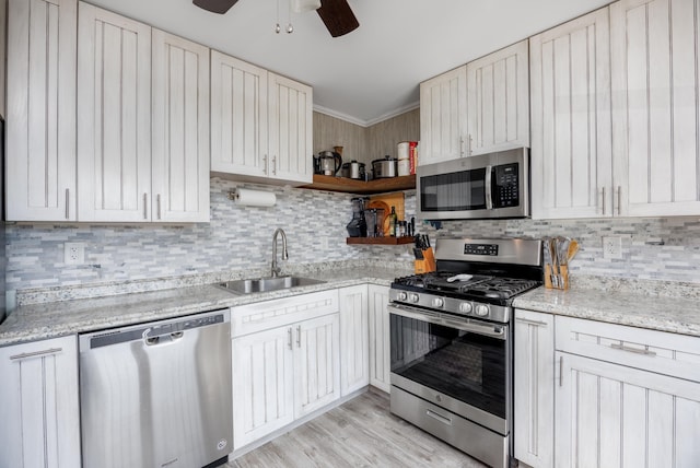 kitchen featuring white cabinetry, sink, light stone countertops, and appliances with stainless steel finishes