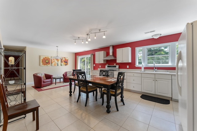 dining area featuring light tile patterned floors, visible vents, and plenty of natural light