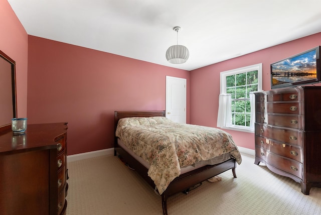 bedroom with baseboards and light colored carpet