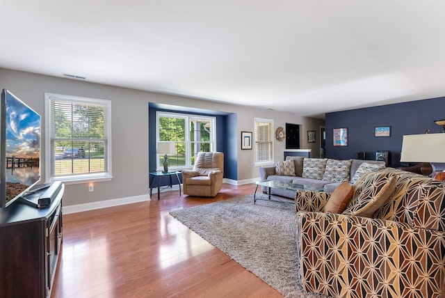 living room with visible vents, baseboards, and wood finished floors