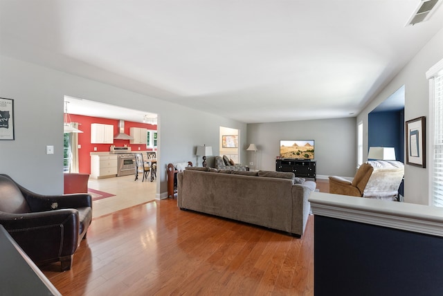 living area featuring light wood-style flooring and visible vents