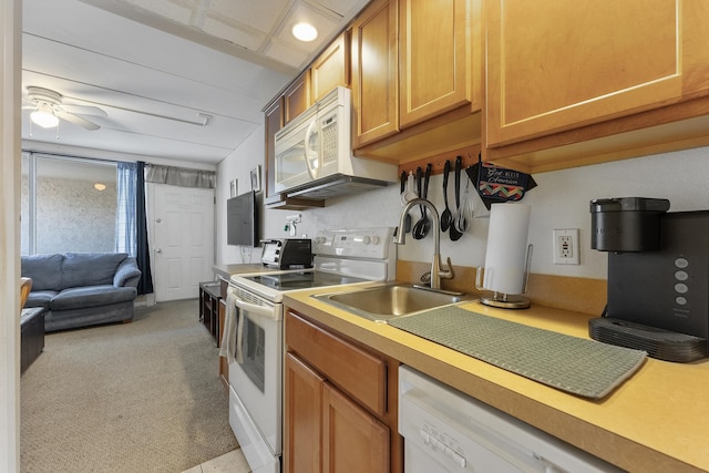 kitchen with sink, white appliances, and ceiling fan