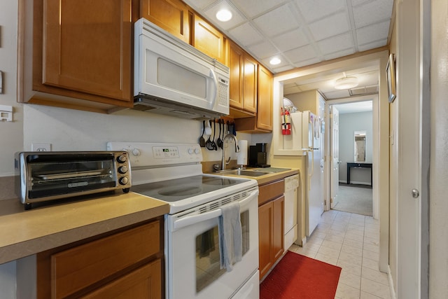 kitchen featuring sink, white appliances, and light tile patterned floors