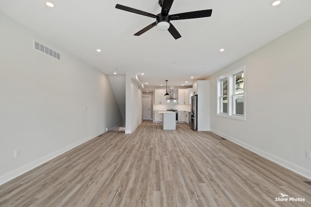 unfurnished living room featuring light wood-style floors, a ceiling fan, recessed lighting, and baseboards