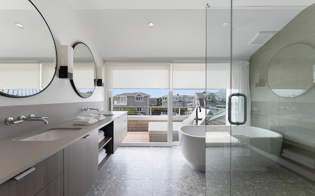 bathroom featuring a wall of windows, vanity, and separate shower and tub