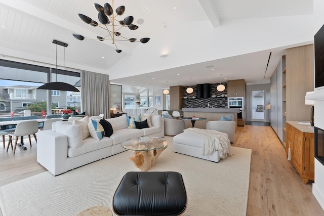 living room with beamed ceiling, high vaulted ceiling, light hardwood / wood-style flooring, and a notable chandelier