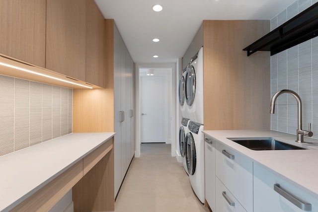 clothes washing area with sink and stacked washer and clothes dryer