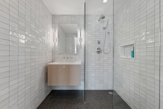 bathroom with sink, tile walls, and a tile shower