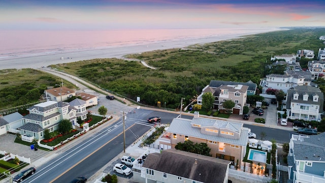 aerial view at dusk featuring a water view