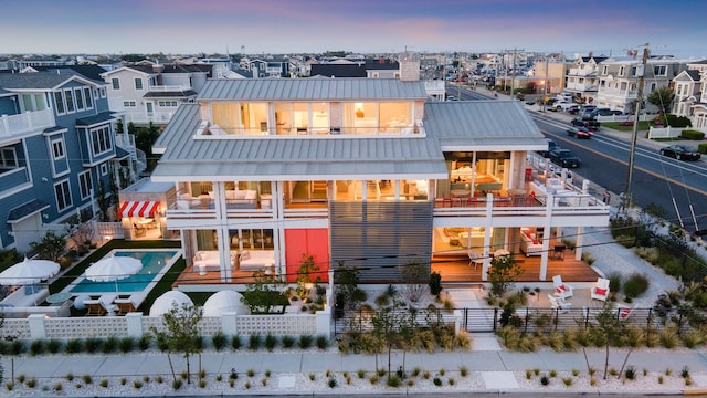 back house at dusk featuring a balcony