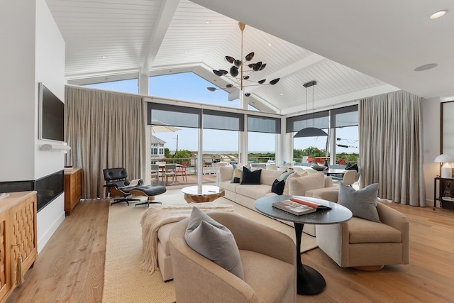 living room with light hardwood / wood-style flooring, high vaulted ceiling, and beamed ceiling