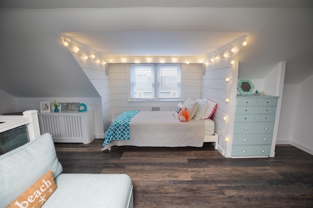 bedroom with wooden walls, baseboards, and wood finished floors