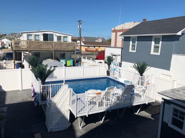view of swimming pool featuring a fenced backyard, a wooden deck, and a fenced in pool