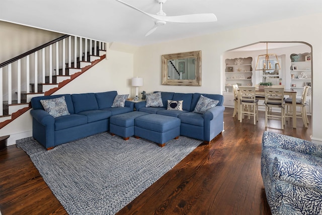 living room with ceiling fan, stairway, arched walkways, and hardwood / wood-style flooring