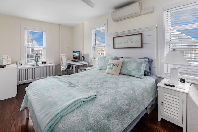 bedroom featuring wood finished floors, a wall mounted air conditioner, and radiator heating unit