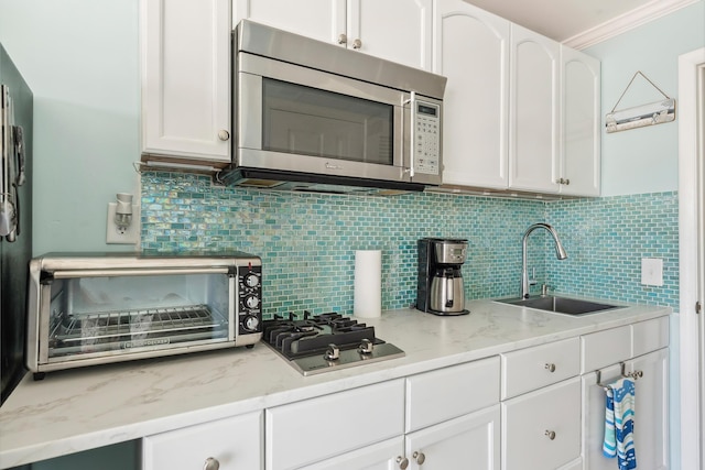 300 Ocean Ave Unit 201, North Wildwood, NJ 08260 - kitchen featuring appliances with stainless steel finishes, a sink, white cabinets, backsplash, and crown molding