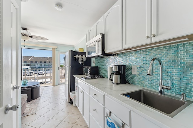300 Ocean Ave Unit 201, North Wildwood, NJ 08260 - kitchen featuring a sink, appliances with stainless steel finishes, decorative backsplash, white cabinetry, and light tile patterned floors