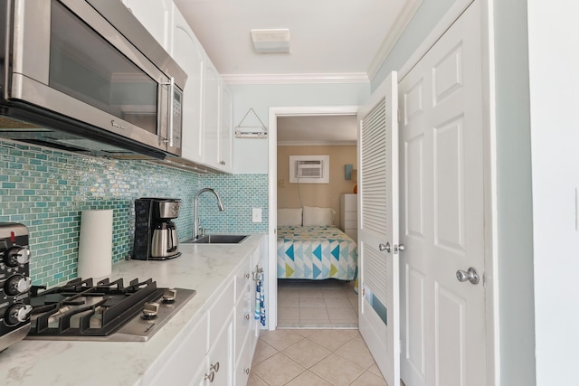 300 Ocean Ave Unit 201, North Wildwood, NJ 08260 - kitchen featuring stainless steel appliances, a sink, ornamental molding, white cabinets, and light stone countertops